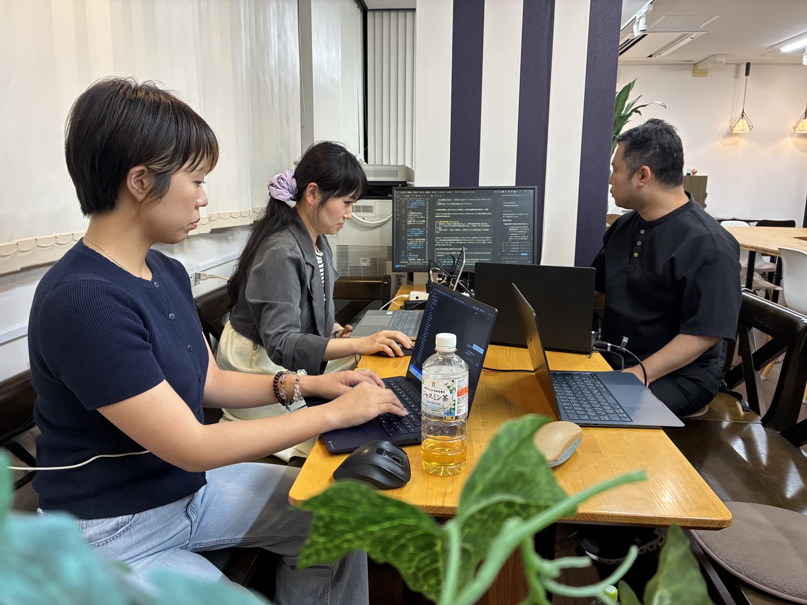 テーブルに並んで座り、それぞれのノートPCで作業を進めている様子